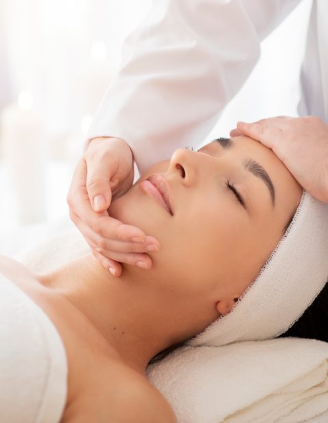 Masseuse Lady Making Face Lifting Massage To Indian Woman In Spa Salon